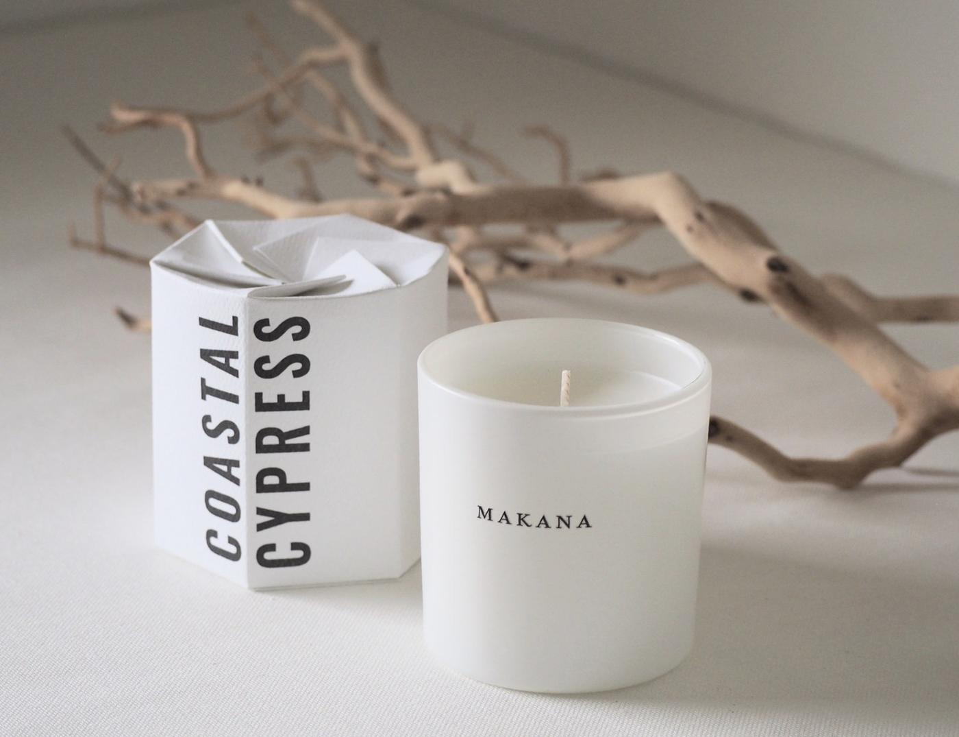 Two white candles beside driftwood