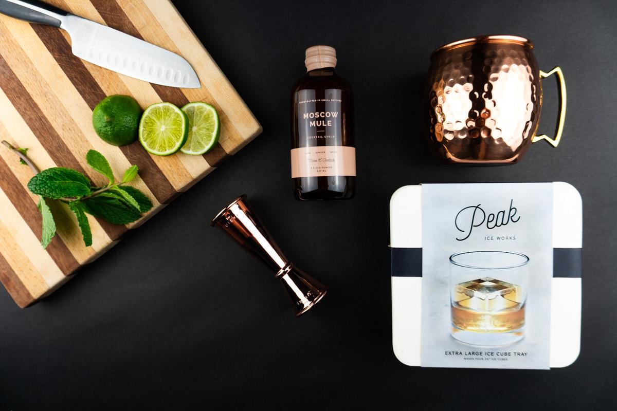 Limes, mint, and the copper mug set on a cutting board