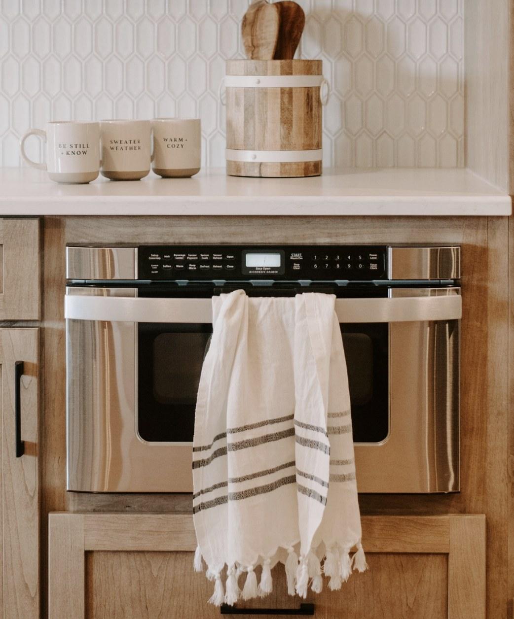 Striped kitchen hand towel hanging from an oven door