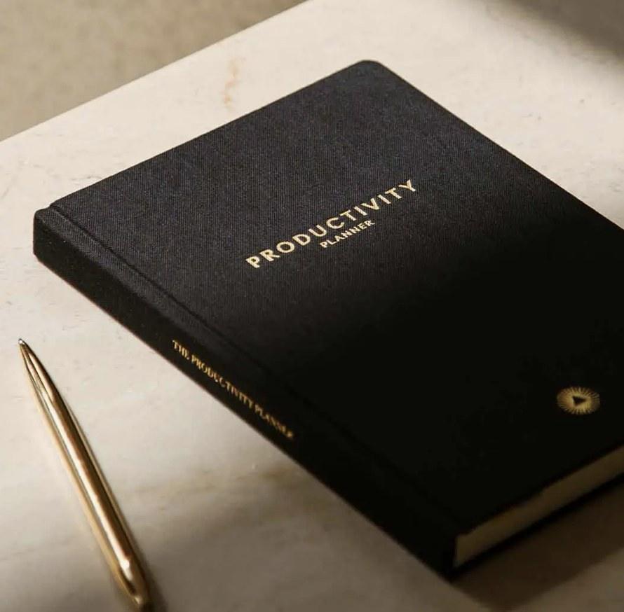 Black Productivity Planner with a pen