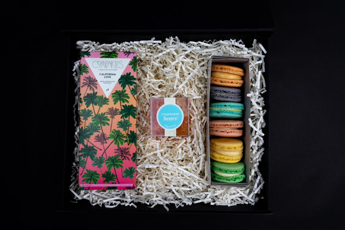 Sweet Tooth box: chocolate bars, Sugarfina candy, and a row of macarons
